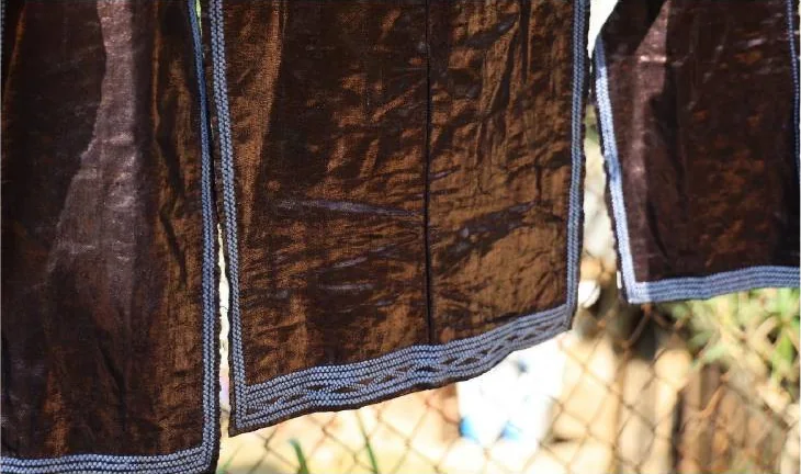 Dark polished hanging textile with blue-and-white geometric border