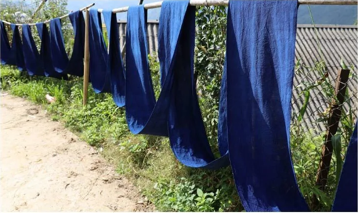 Close view of deep-blue cloth hanging over bamboo rails